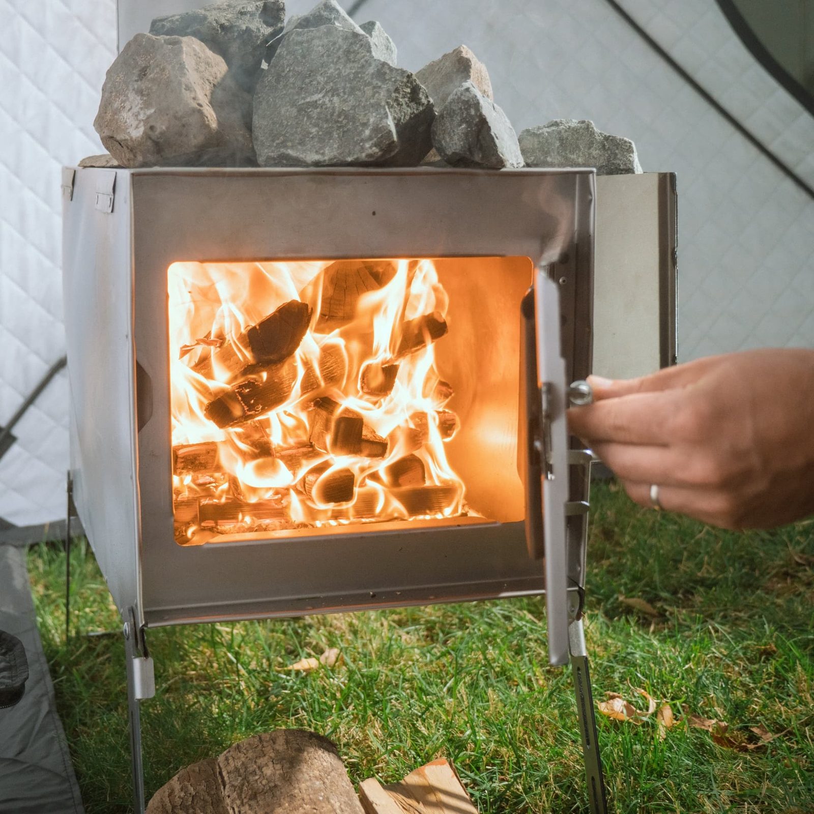 Superlite stove roaring with a full wood fire and sauna stones on top